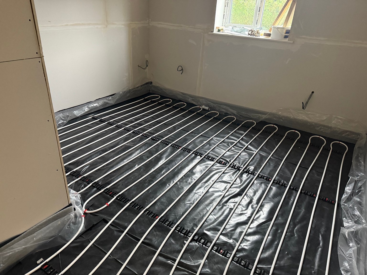 Underfloor heating pipe loops installed across room